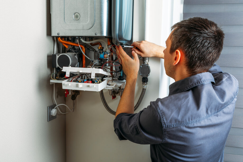 water line repair Plumber attaches Trying To Fix the Problem with the Residential Heating Equipment. Repair of a gas boiler